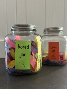 Two lidded glass jars, Bored Jar and Job Jar displayed