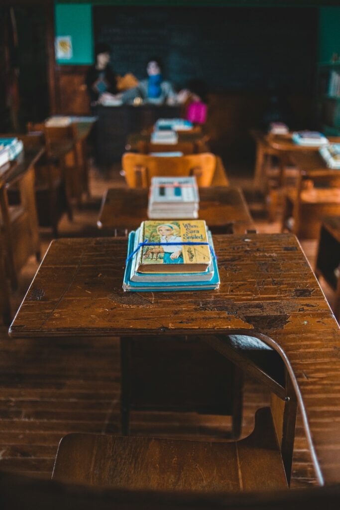 an old schoolroom with vintage wooden desk chairs and picture books