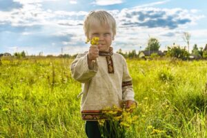 preschooler celebrating spring outside in a field of wildflowers