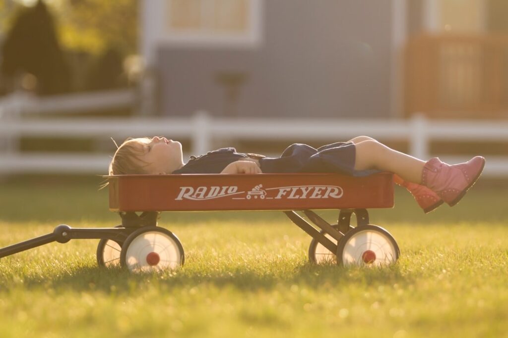 preschooler age boy with unfilled time relaxing and dreaming in a wagon