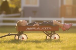 preschooler age boy with unfilled time relaxing and dreaming in a wagon